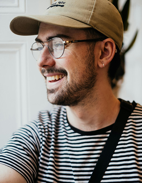 younger man posing with hat